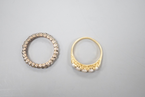 A 19th century yellow metal and rose diamond set full eternity ring, size L/M and an early 20th century yellow metal and graduated split pearl ring, size K/L, gross weight 5.8 grams.